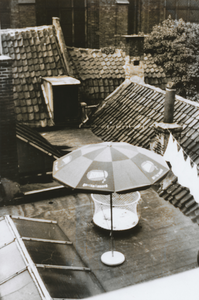 874871 Gezicht op het dakterras van het pand Oudegracht 45 te Utrecht, met een parasol en een box voor de kinderen ...